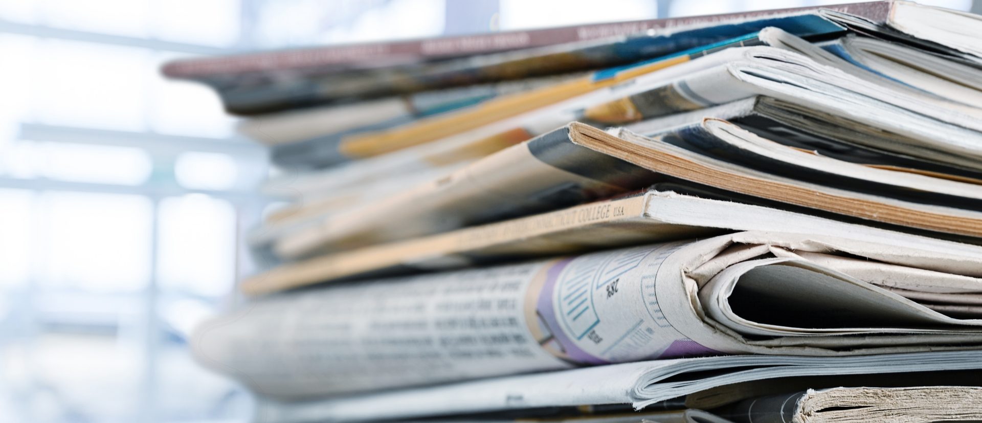 Das Bild zeigt einen Stapel von Zeitschriften und Zeitungen. Die Dokumente sind unordentlich übereinander gestapelt, was darauf hindeutet, dass es sich um eine Sammlung oder einen Vorrat handelt. Einige der Dokumente sind sichtbar zerknittert oder leicht abgenutzt, was darauf hinweist, dass sie möglicherweise schon häufiger gelesen oder durchgeblättert wurden. Die Bildaufnahme könnte in einem Büro oder einem häuslichen Umfeld gemacht worden sein, wo solche Stapel von Papier häufig anzutreffen sind. Es vermittelt einen Eindruck von Information, Nachrichten, oder Kultur, die in gedruckter Form vorliegt. **