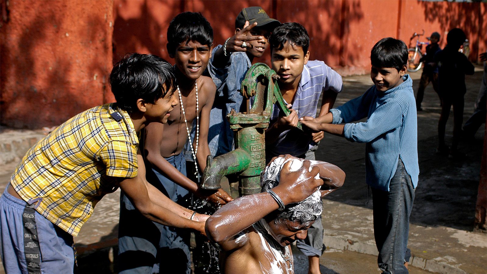 Kinder waschen sich am Brunnen