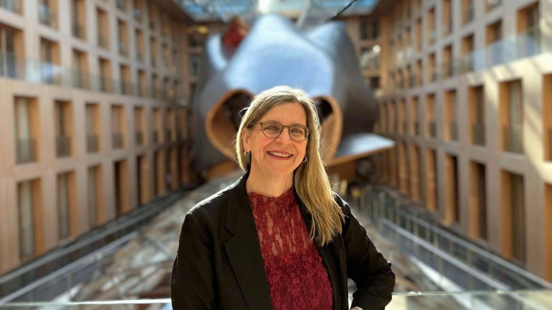 Das Bild zeigt eine große, kurvenreiche Skulptur oder Kunstinstallation in einem modernen Gebäude mit einer Reihe von Fenstern und einem Glasdach. Es scheint sich um eine architektonisch interessante Umgebung zu handeln.