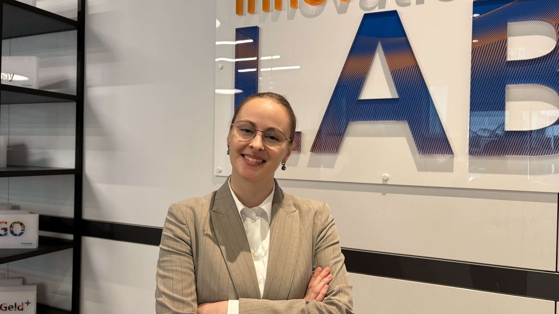 Das Bild zeigt einen Bereich mit der Aufschrift "LAB", vermutlich in einem Innovationslabor oder einer ähnlichen Einrichtung. Es gibt auch Regale mit verschiedenen Gegenständen im Hintergrund.