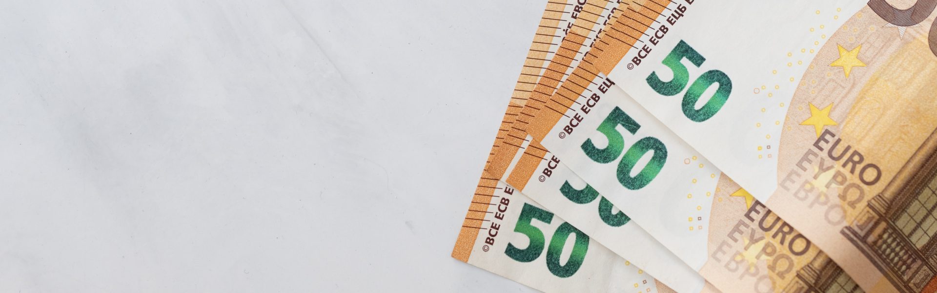Das Bild zeigt mehrere 50-Euro-Geldscheine, die teilweise übereinander liegen.