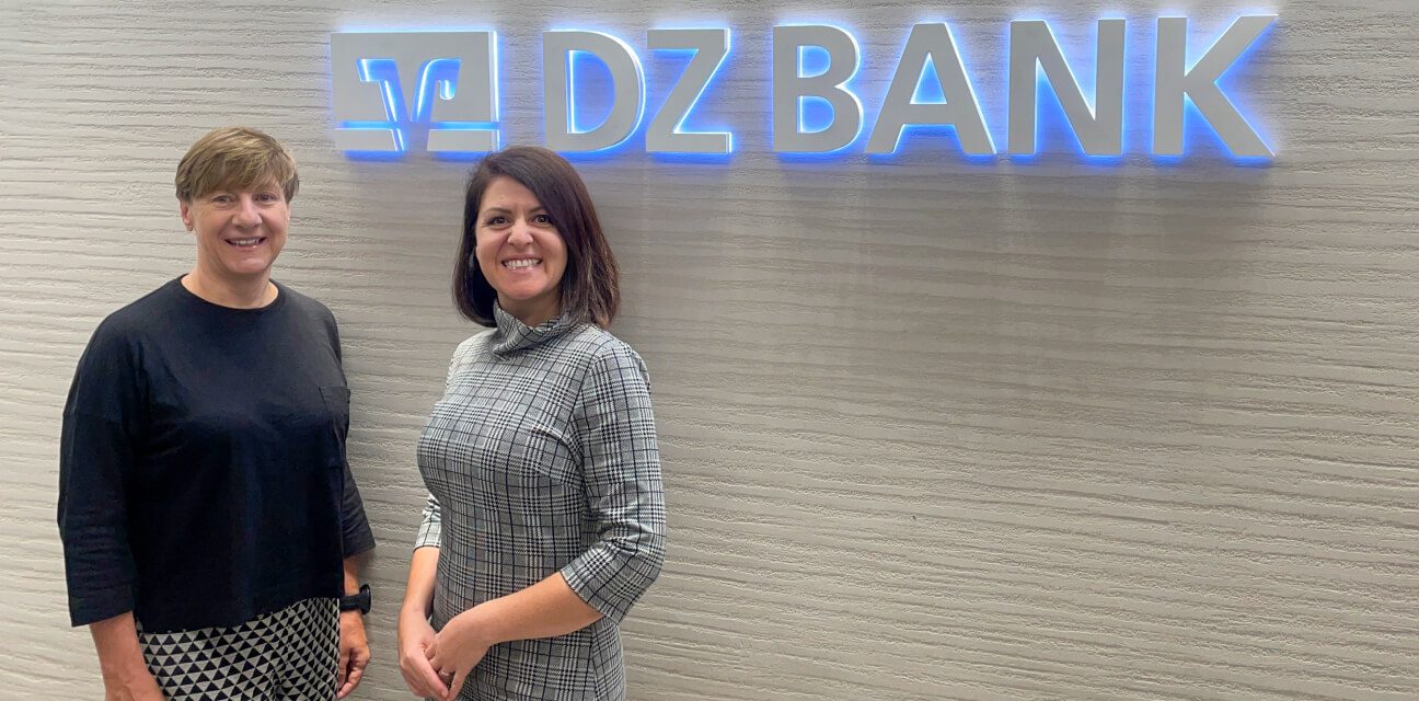 Two DZ BANK team members under the logo and word mark of DZ BANK