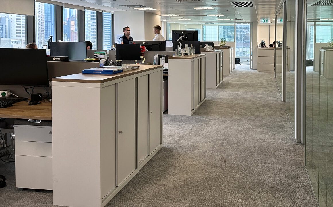 A view into an open plan office where DZ BANK Hong Kong’s team can be seen busy discussing and working on client’s requests